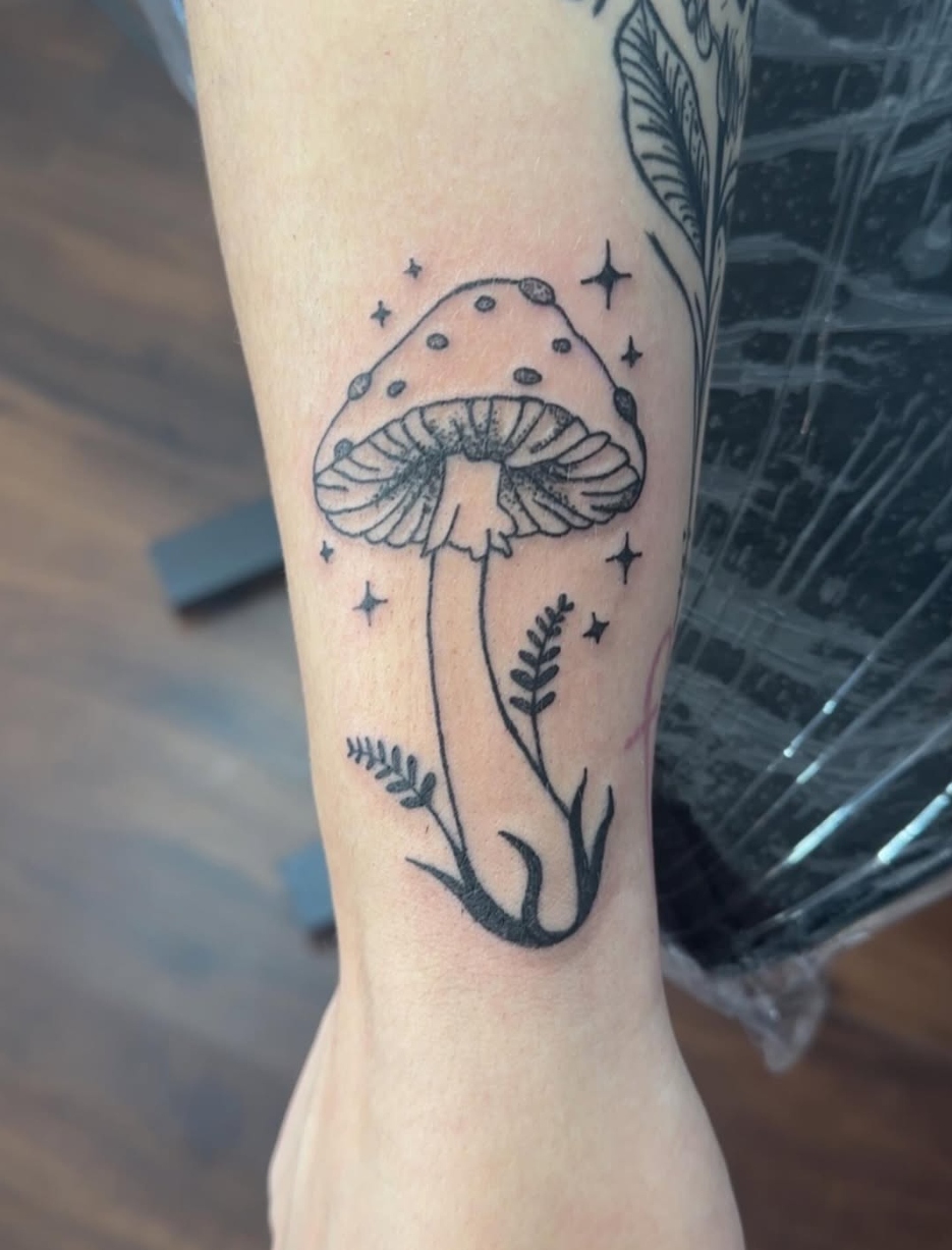 Books camera and floral sleeve tattoo